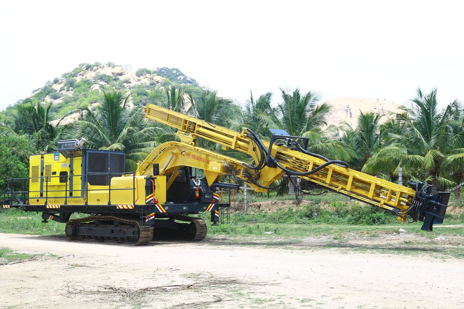 Velson Ground Hog crawler drill, articulated boom holding the feed beam out at an angle over open ground