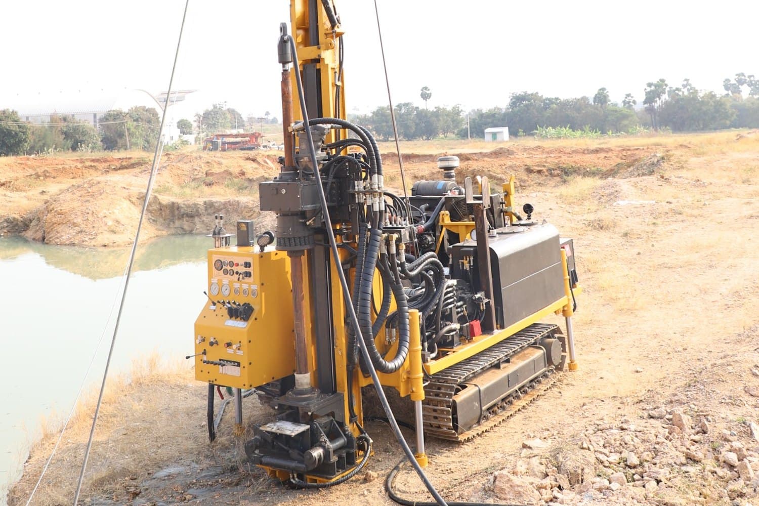 Velson VEDC 80 diamond-core drill working a pit edge - rotary head on the mast, driller's control panel and hydraulic hose runs alongside the crawler