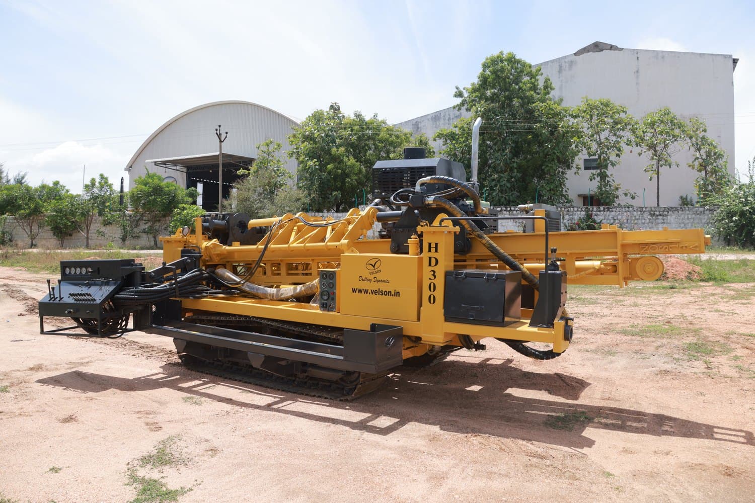 Velson HD300 horizontal drill on a tracked carrier, feed beam laid out along the machine with the plant sheds behind
