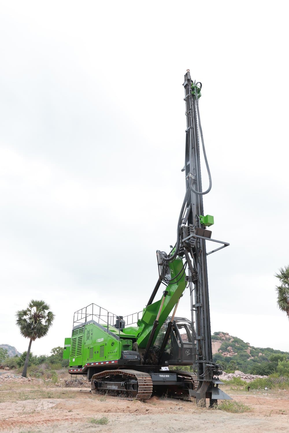D120 crawler on a working bench with the mast vertical and the rod in the feed, deck walkway and handrail above the engine canopy